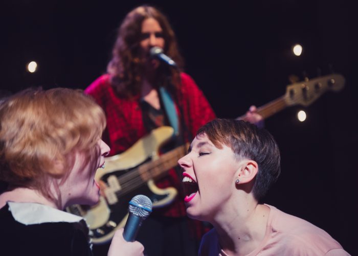 Kylie and Georgie sing into a microphone for Ask Me Anything