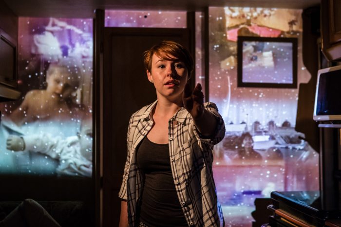 Georgie Coles reaches out on the Mobile set with beautiful projections in the background