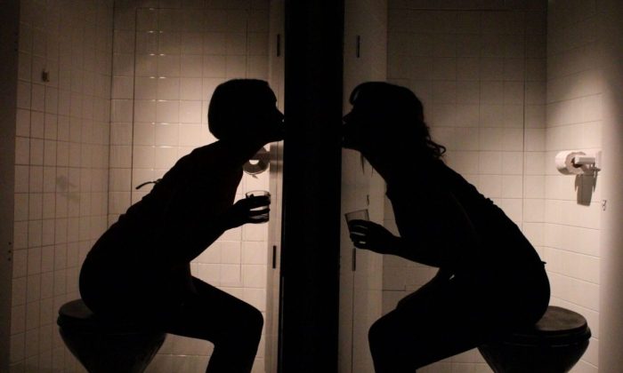 Image from Thirsty showing two females next to each other in toilet cubicles with drinks in their hands