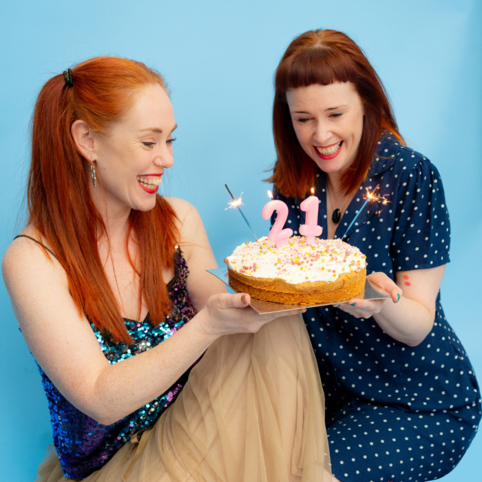 Jemma and Kylie enjoying a cake with candles for The Paper Birds 21st Birthday